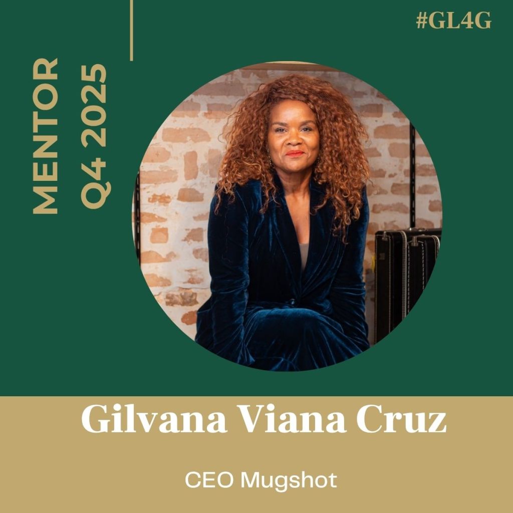 Portrait of Gilvana Viana Cruz, CEO of Mugshot, seated against a rustic brick background, wearing a navy blue suit and smiling. Text overlay indicates she is a mentor for Q4 2025.